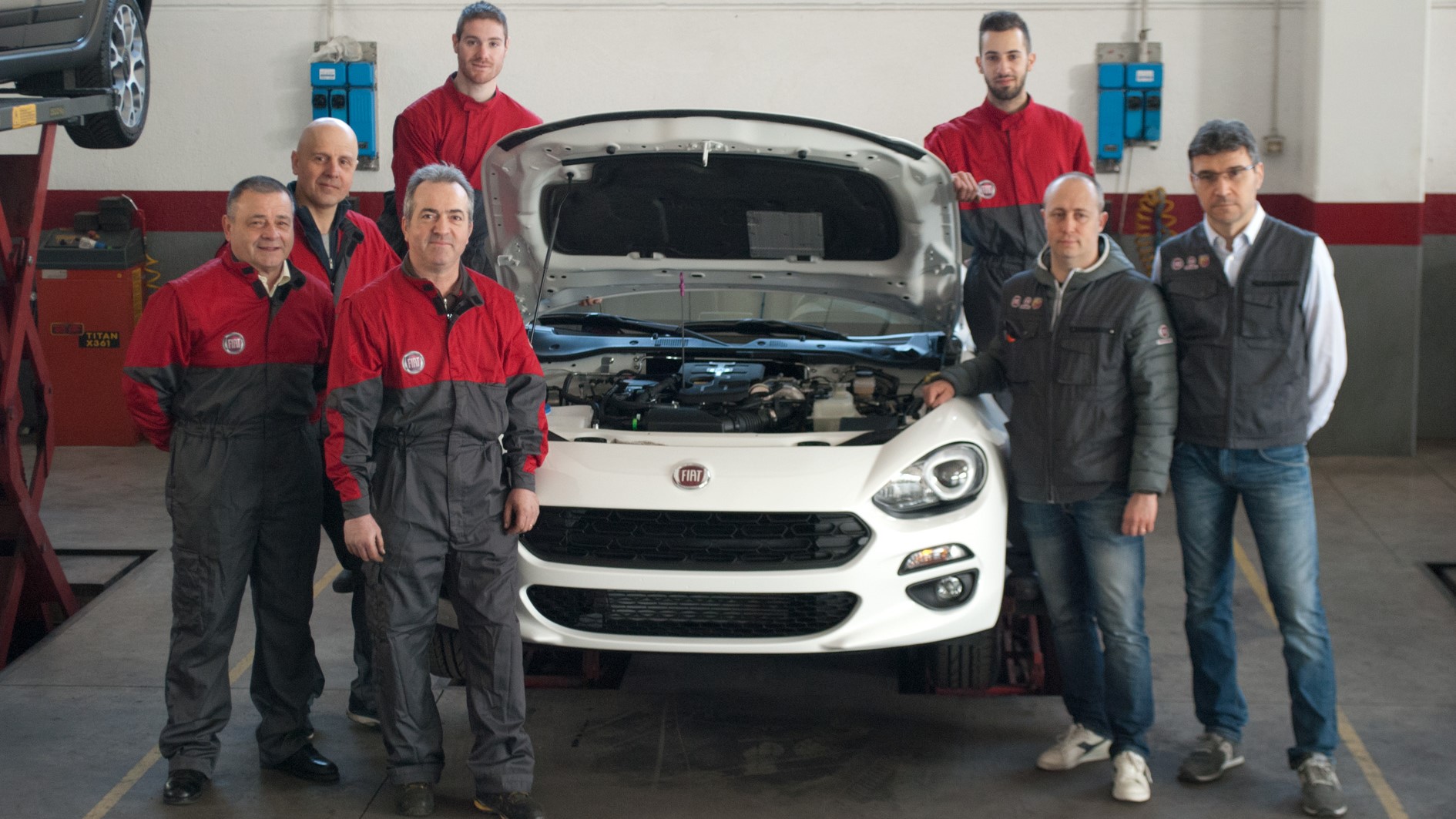 Il team AllCars in officina con una Fiat bianca.